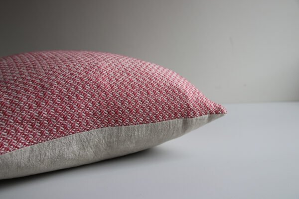 wool and cotton cushion in rose pink showing the side detailing and handwoven design